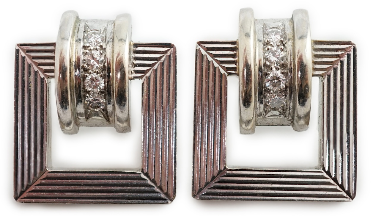 A modern pair of 14k white gold and four stone diamond set buckle style earrings (lacking butterflies)